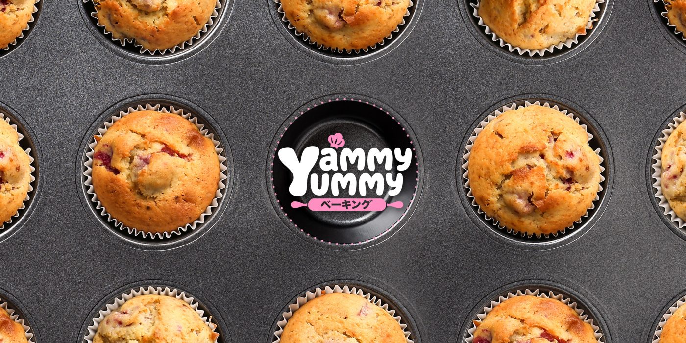 Overhead view of freshly baked muffins in a muffin tin surrounding the Yammy Yummy logo