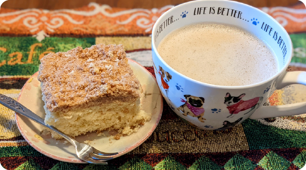 Old-Fashioned Coffee Cake with a crumb topping served beside a cup of coffee